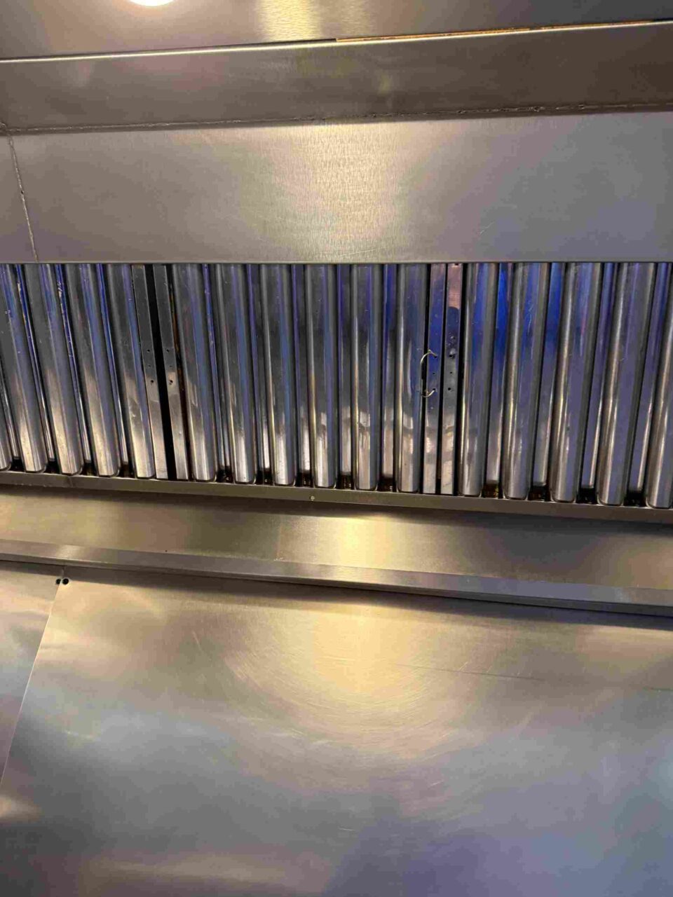 Close-up of stainless-steel baffle filters inside a commercial exhaust hood in Atlanta, GA