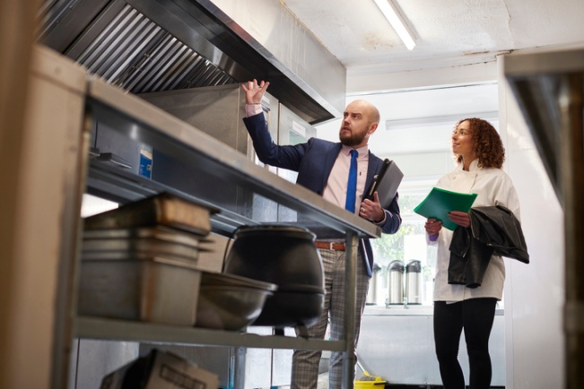 Inspector reviewing a commercial kitchen hood system during an inspection in North Carolina