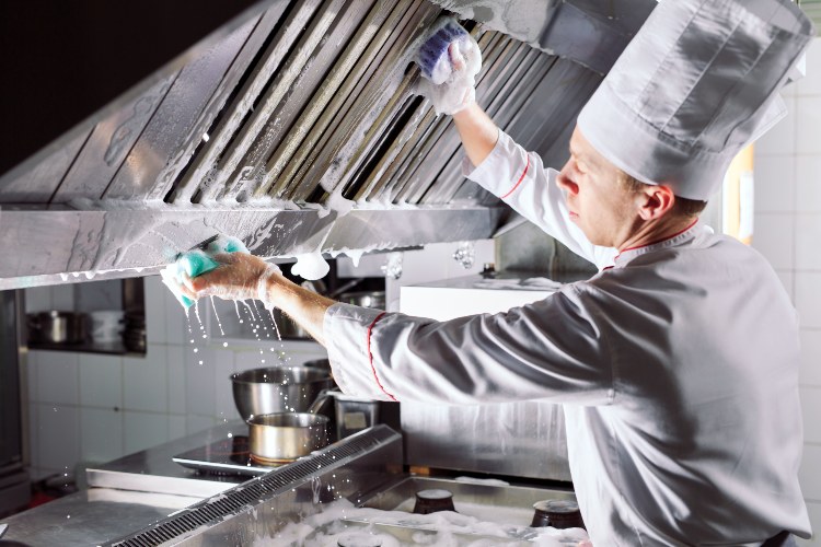 Cleaning stainless steel kitchen hood with soap and water in Asheville, NC