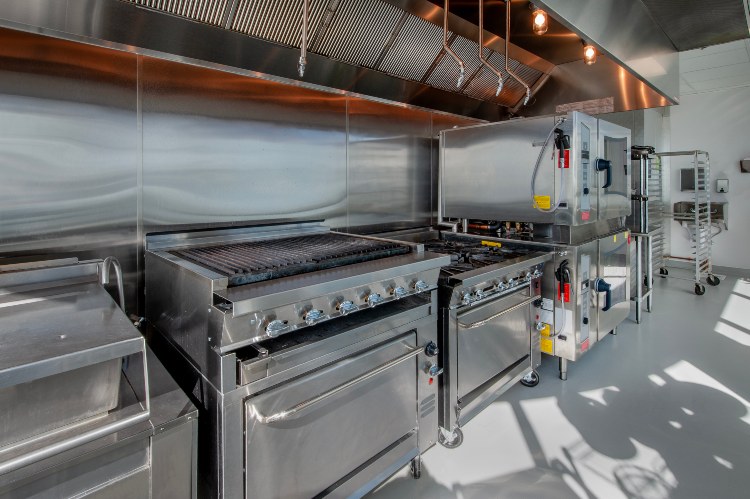 Stainless steel commercial kitchen with grill & oven under vent hood in Atlanta, GA
